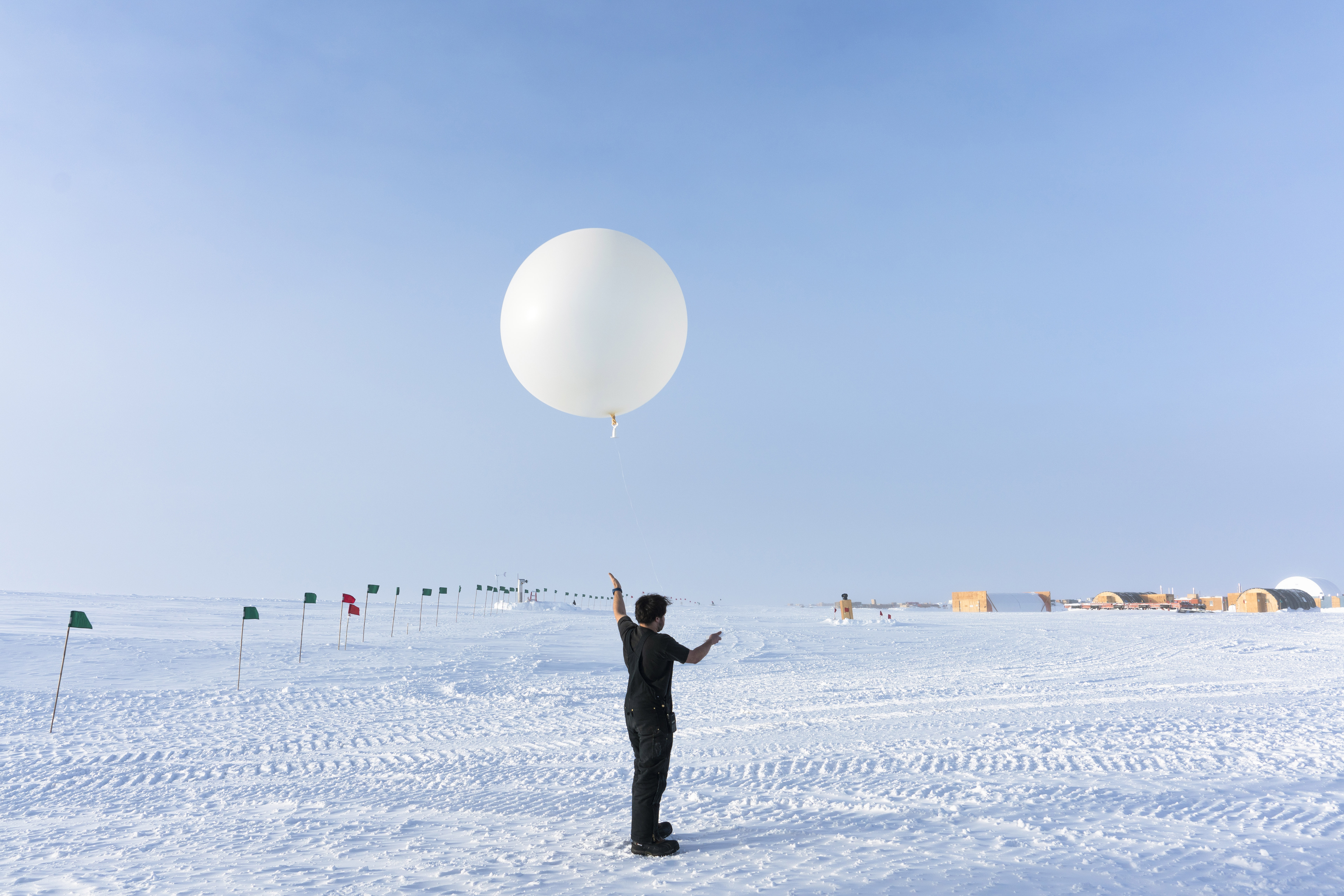 Winterover holding onto a weather balloon before launch.