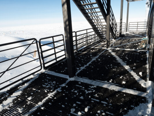 Platform and stairs outside the IceCube Lab after being cleared of snow accumulation.