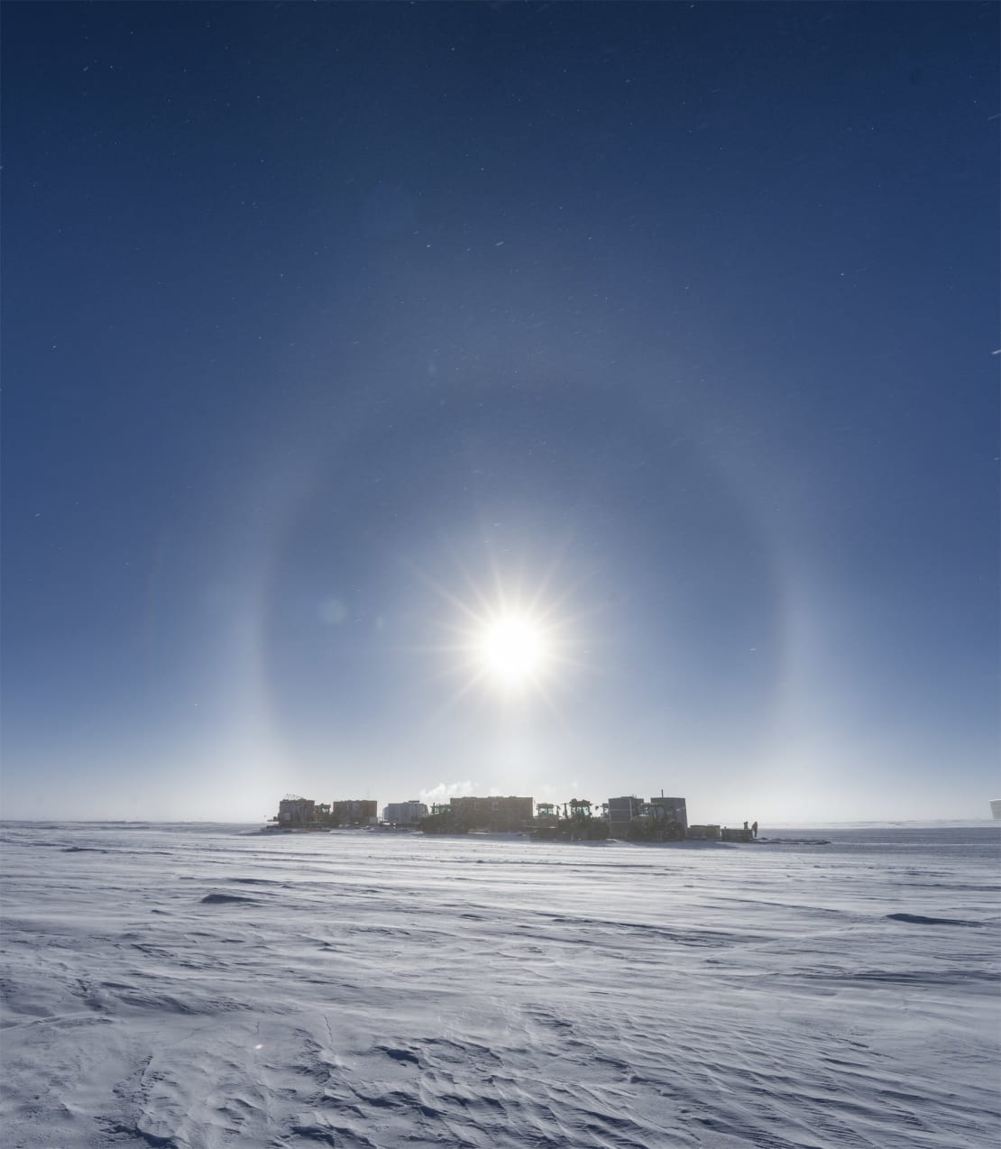 South Pole traverse seen in distance under a sun halo.