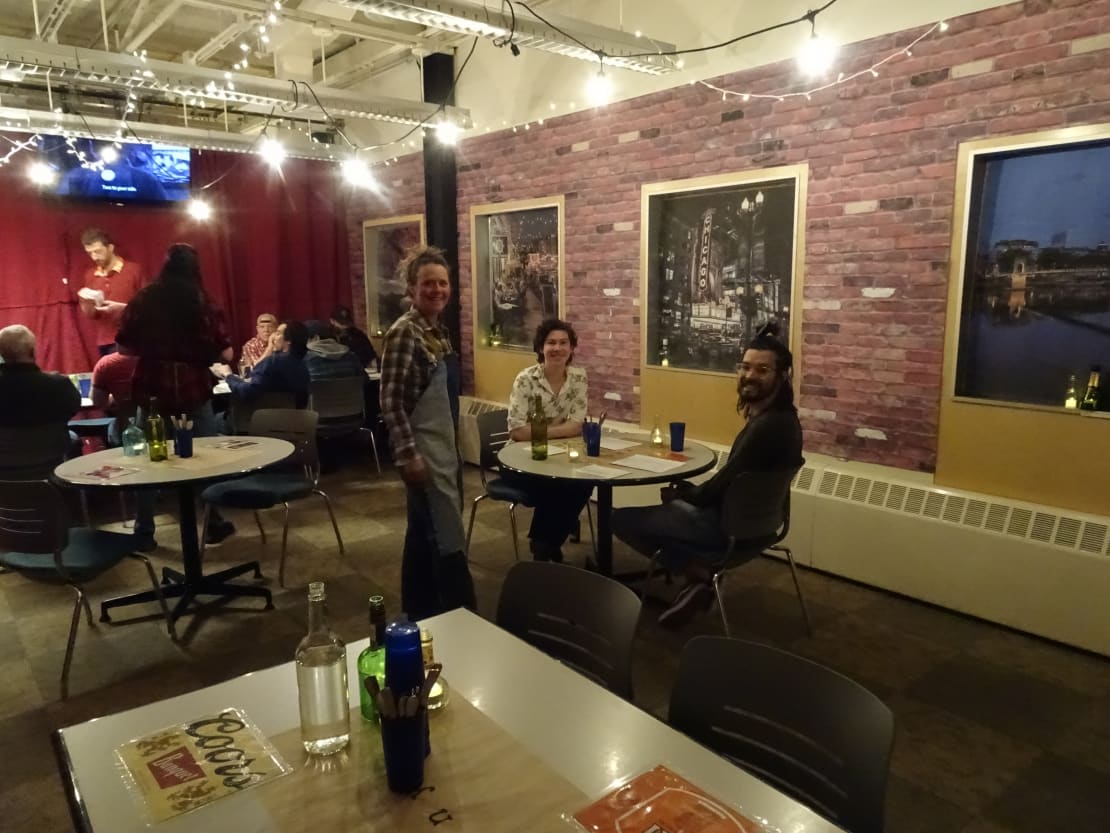 View of seated customers and standing servers in South Pole galley decorated as pop-up restaurant.