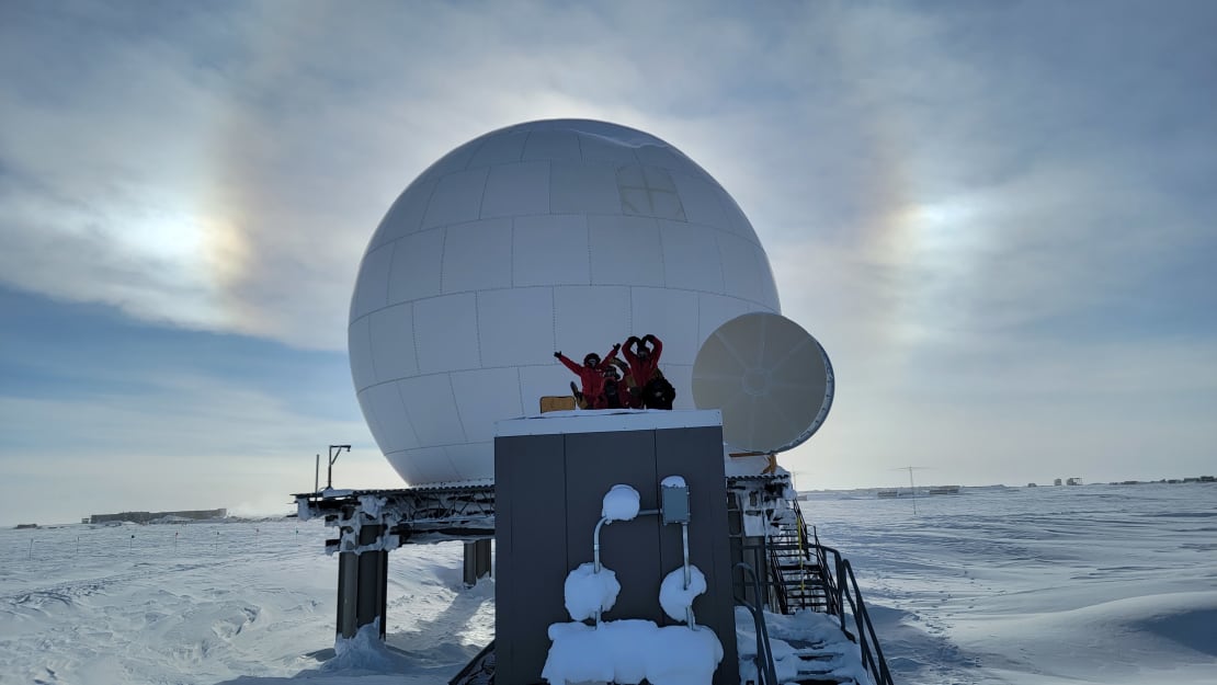 View of satellite dome in shadow, blocking the sun, framed by sun dog.