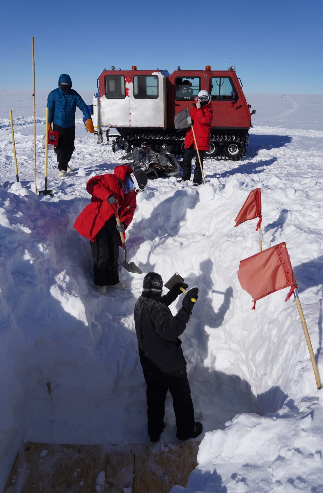 Several people digging in the snow at the South Pole.