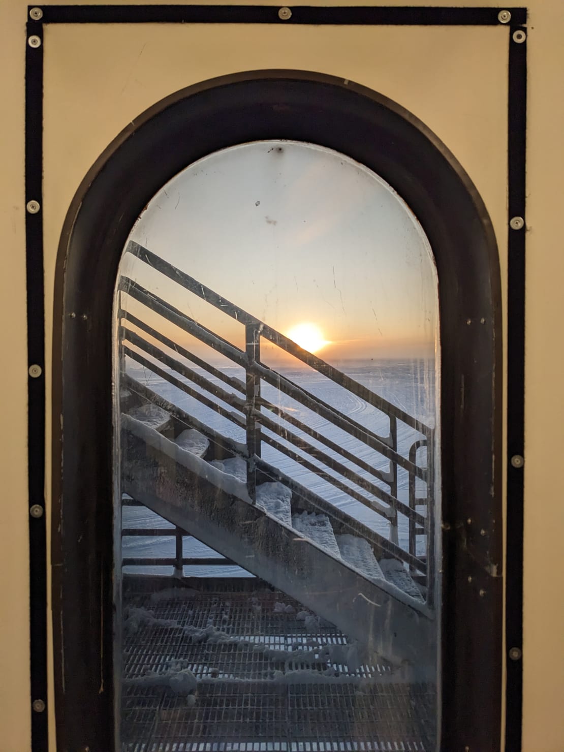 View of the setting sun from out a window of the IceCube Lab.