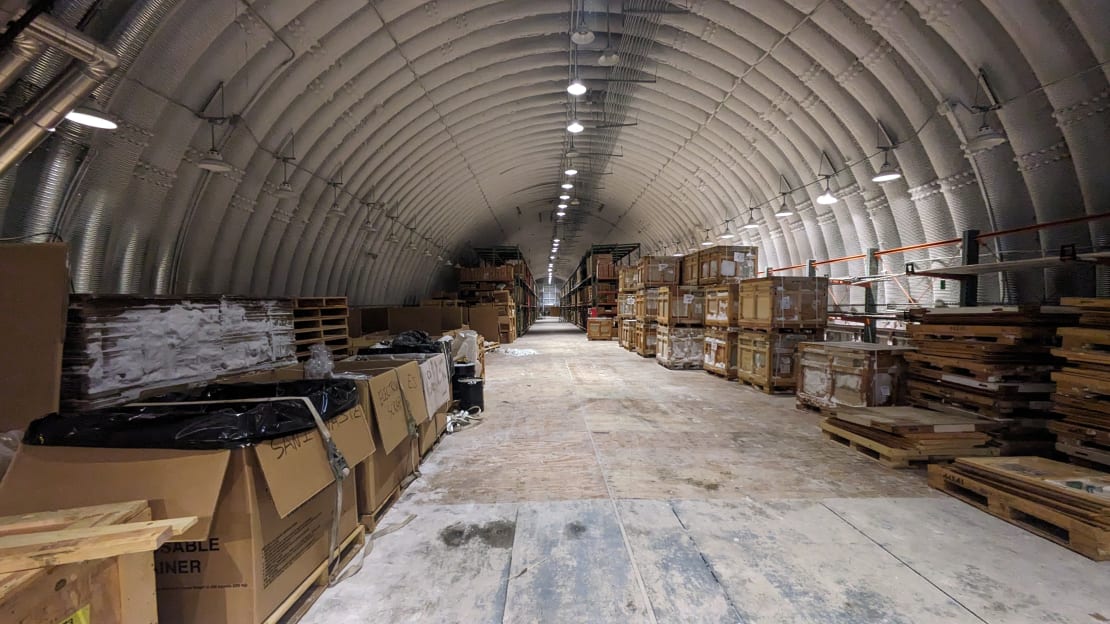 Long view of cold storage area below the South Pole station, with large boxes on pallets lining the walls.