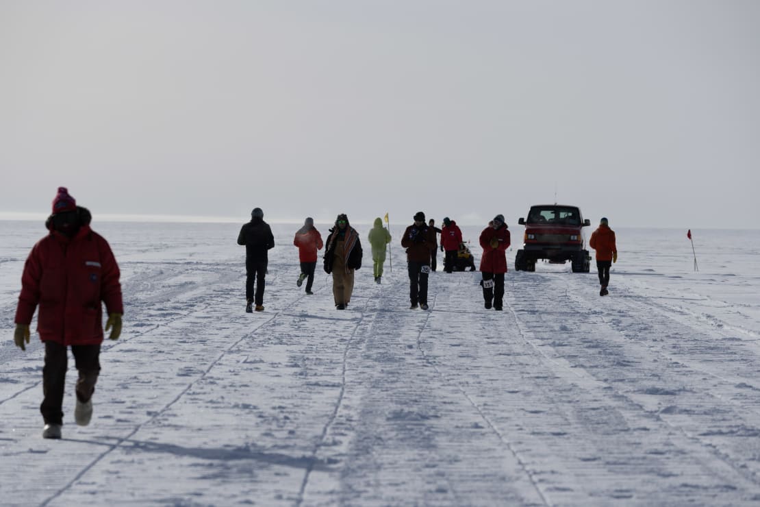 Group of race participants passing each other out on polar ice.