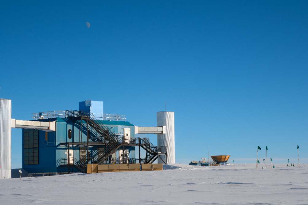 Very faint moon in bright blue sky above the IceCube Lab.