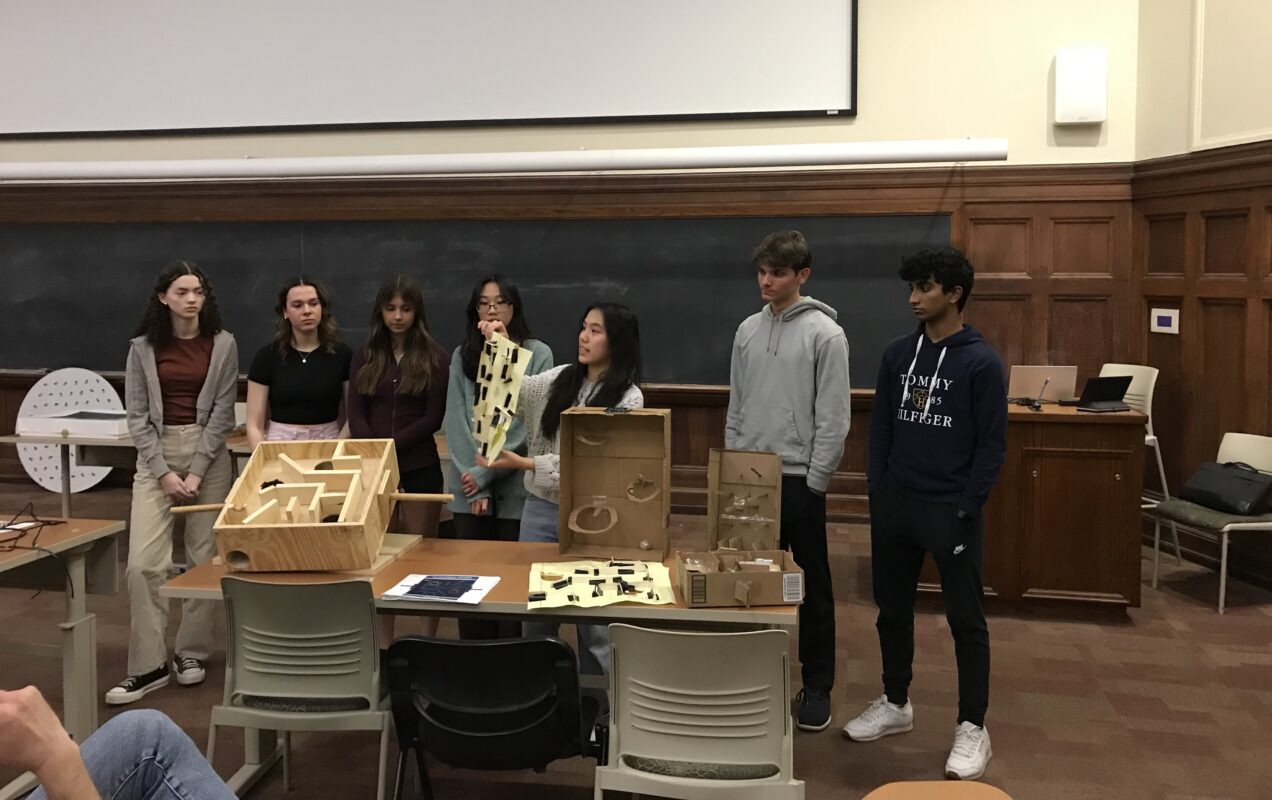 A group of people presenting a project in front of a blackboard