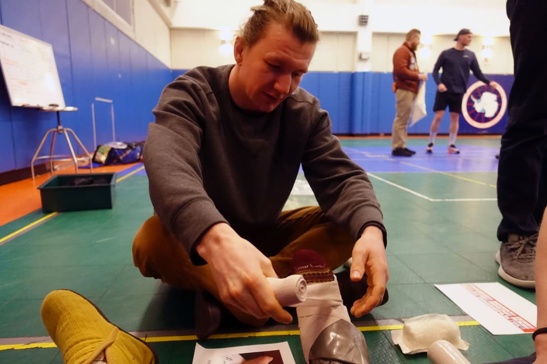 Close-up of seated person bandaging a foot in ERT exercise.