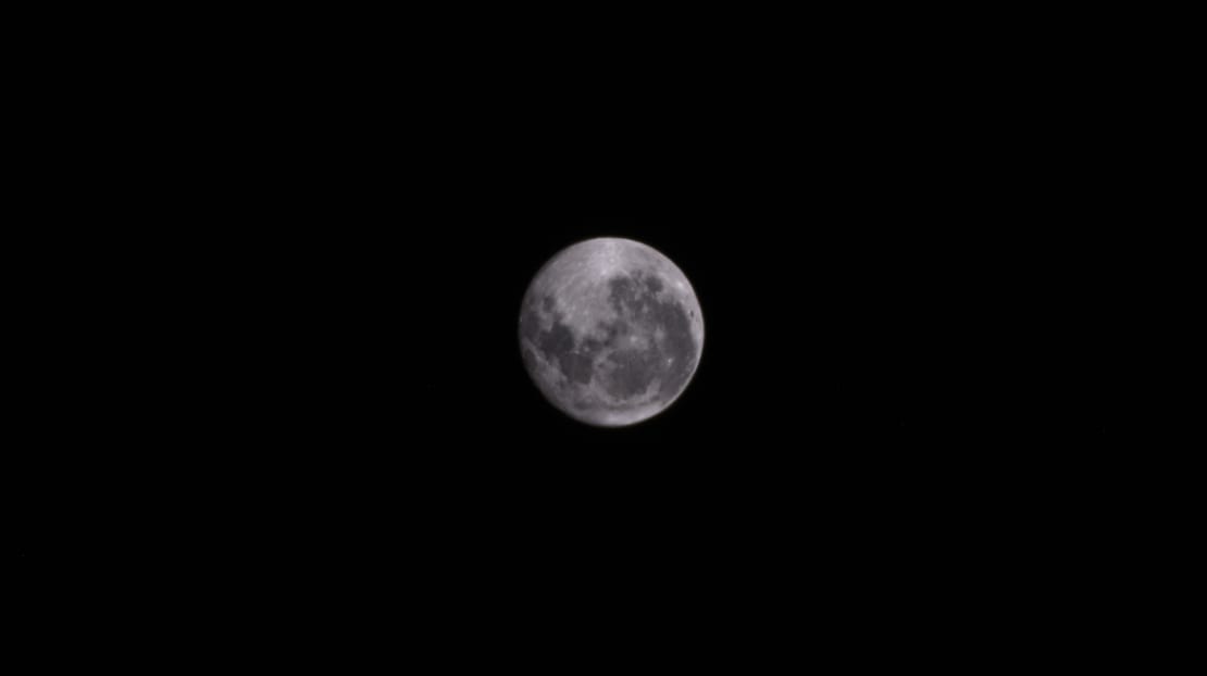 Close-up of moon, black sky background.