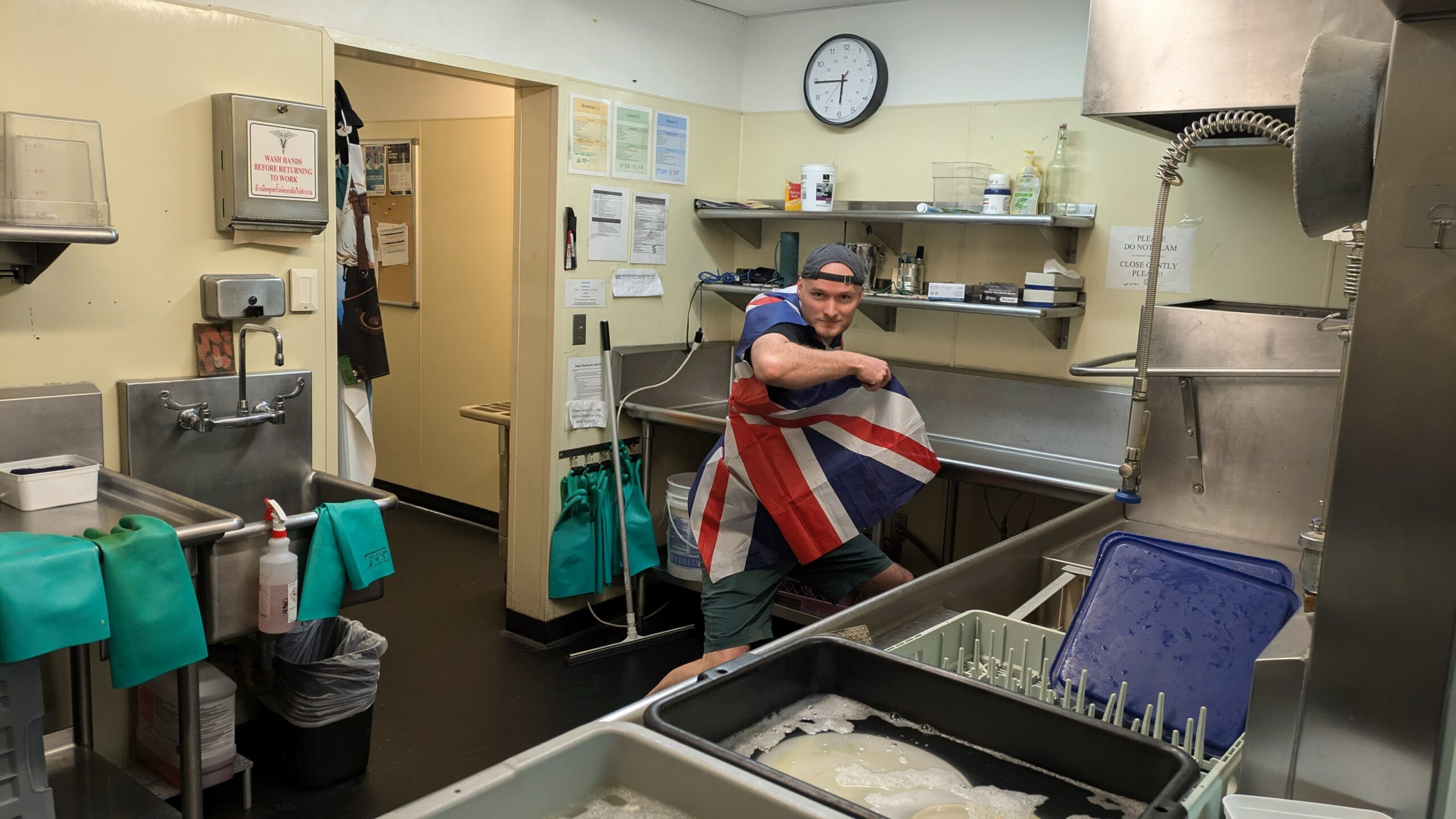 Person facing camera, in the South Pole kitchen, wrapping themselves in a flag.