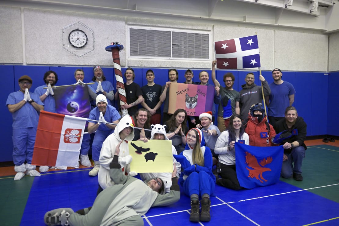 Group photo in South Pole gym with people in costumes and/or holding flags.