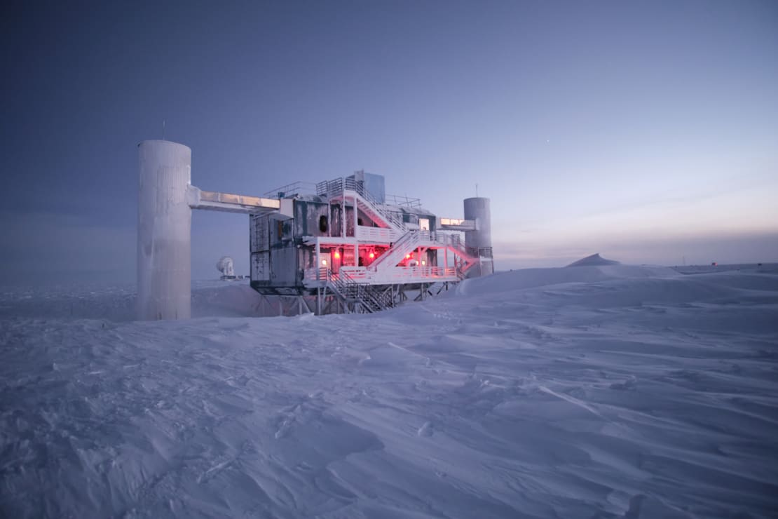 Angled view of frosty IceCube Lab during early sunrise.