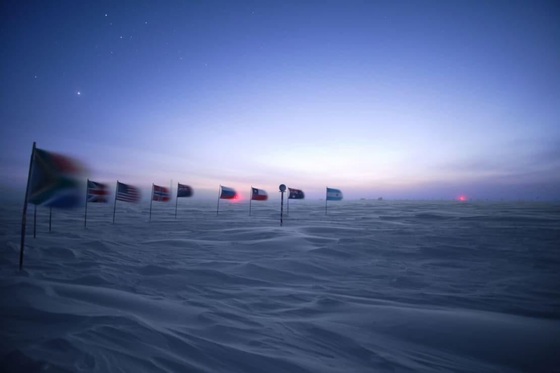 Sky brightening before sunrise, flags at ceremonial Pole flapping in the wind.