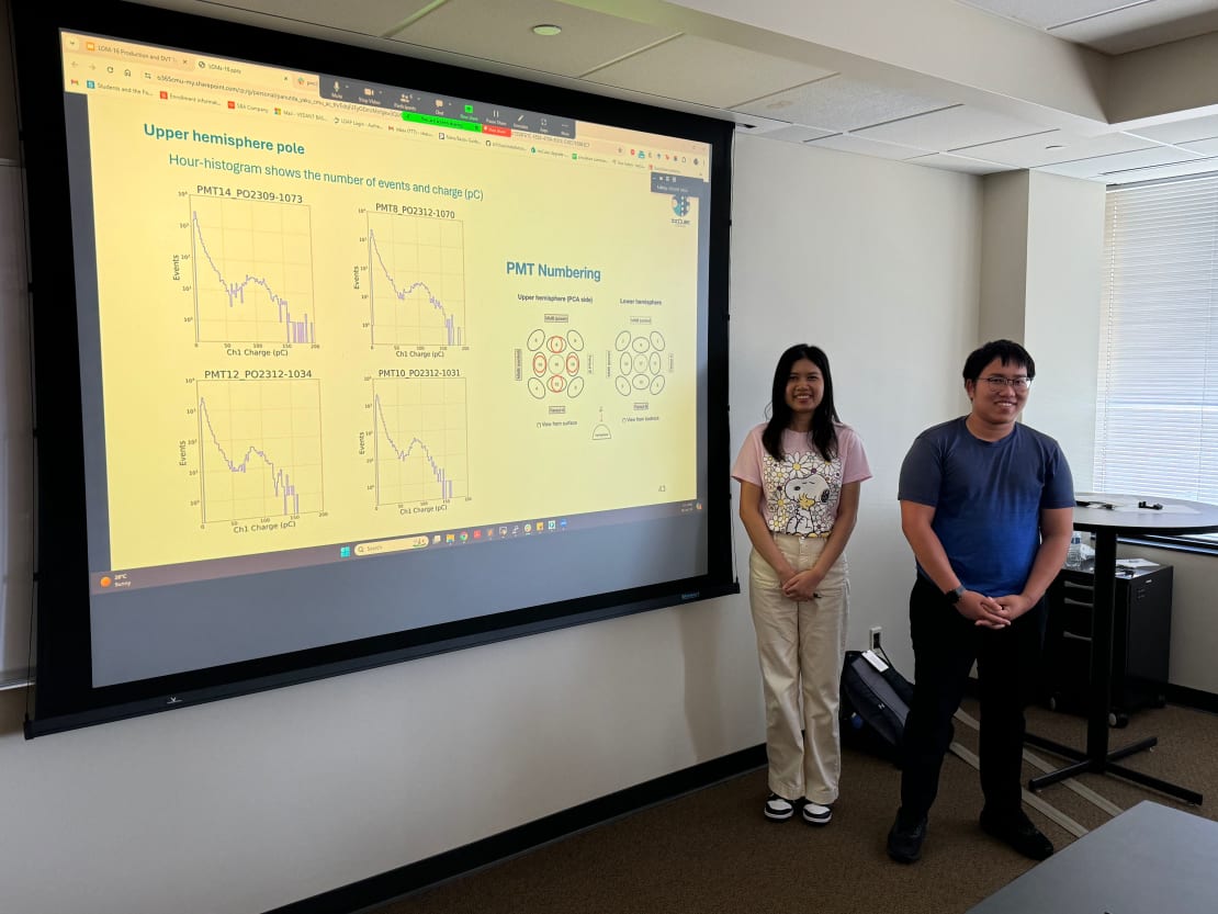 Two students standing in front of a projector screen