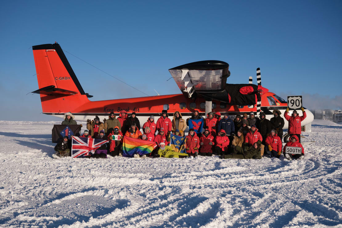 Wintover group photo with a twin otter plane as backdrop.