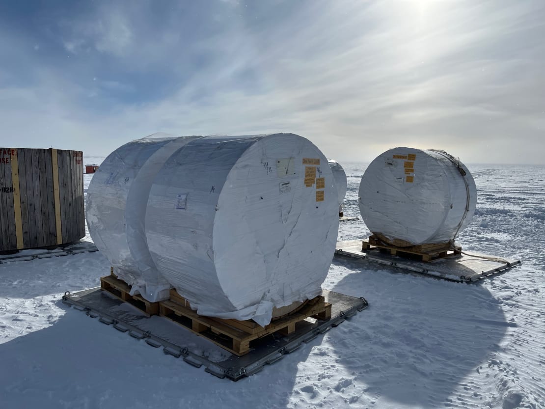 Large cable spools wrapped and on palettes out on the ice.