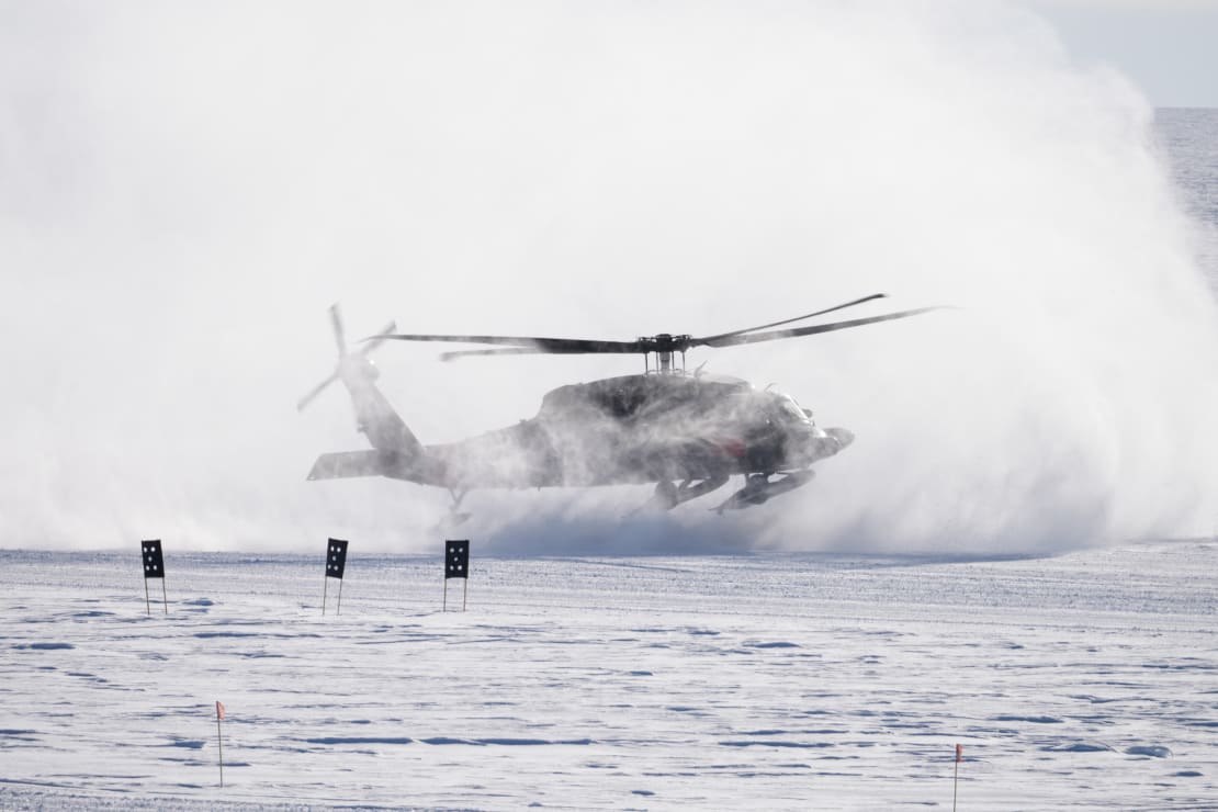 A helicopter whipping up snow as it lands at the South Pole.