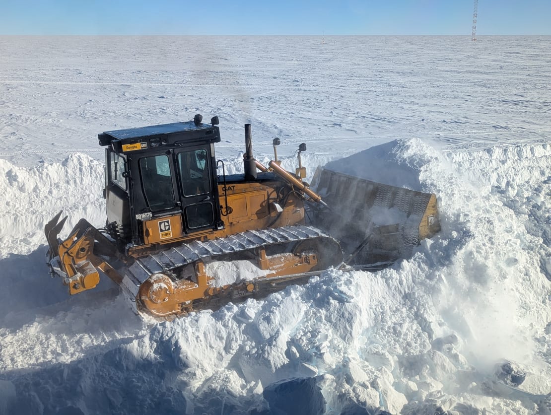 Large bulldozer plowing snow.