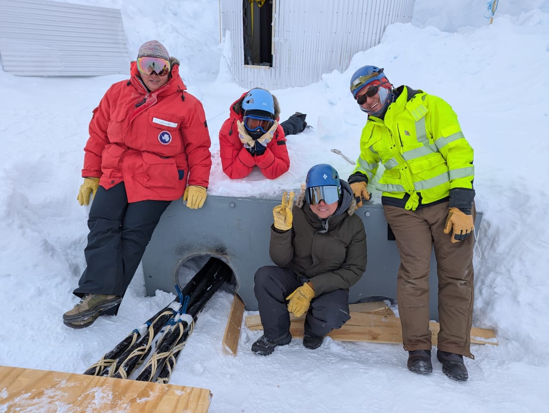 Group of four working outside, posing for the camera.