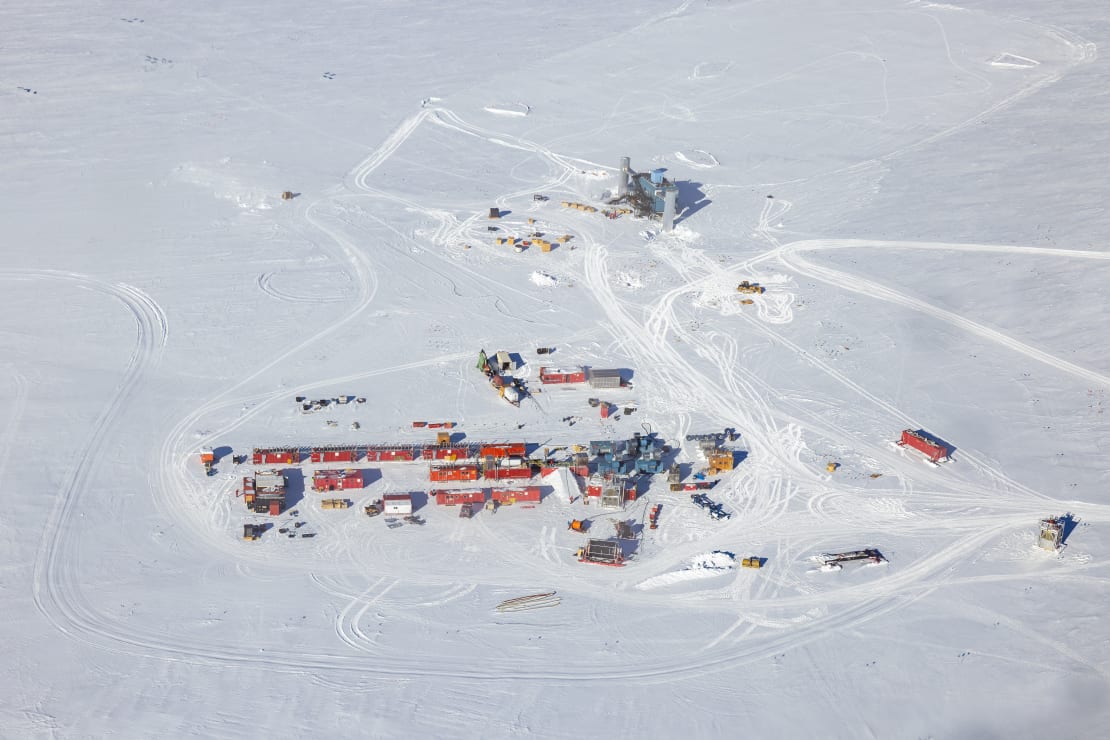 Aerial view of the IceCube Lab and nearby IceCube Upgrade drill camp, with lots of containers and equipment.