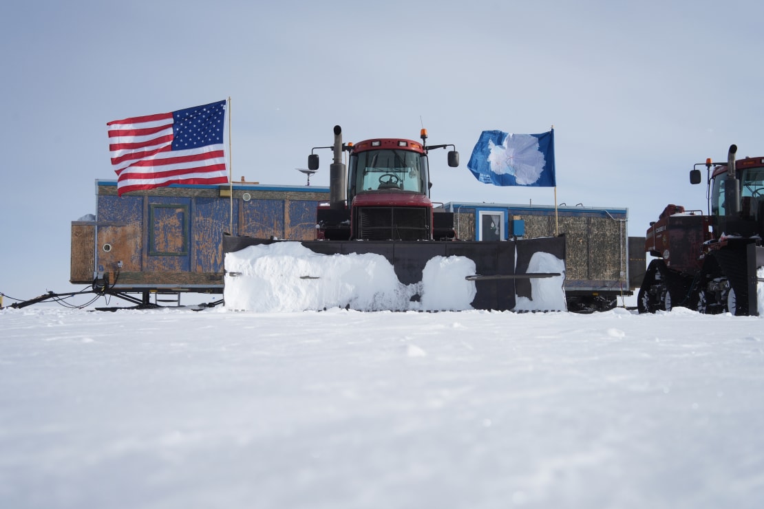 Traverse vehicle and container, with US and Antarctica flags flying.