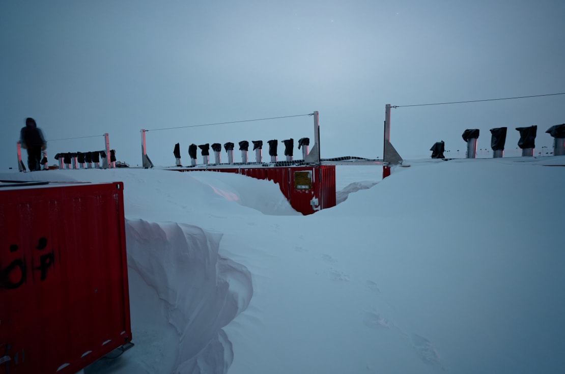 Tall snowdrifts along row of containment structures.