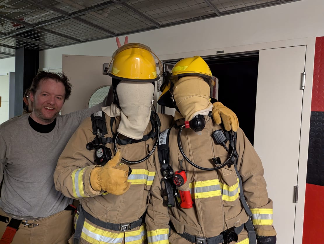 Group of three winterovers in firefighting gear, two with masks covering their faces.