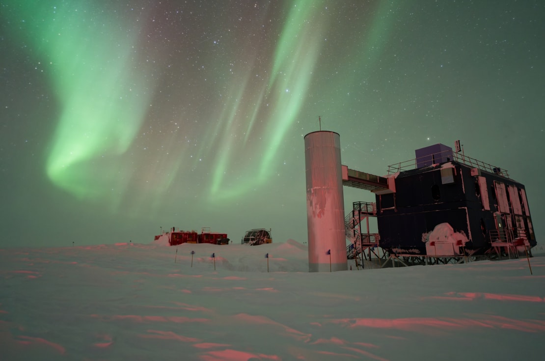Swirling auroras over the IceCube Lab, off to the right.