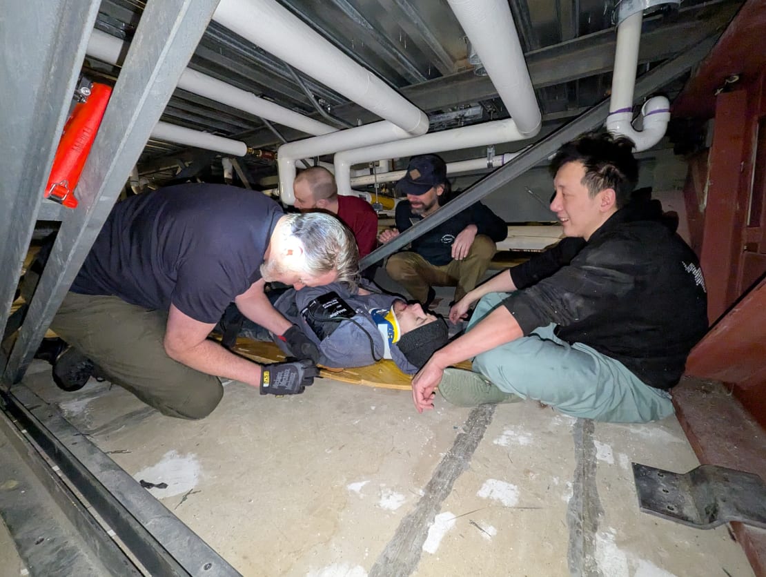 Group in midst of simulated emergency response rescue under the subfloor of South Pole station.