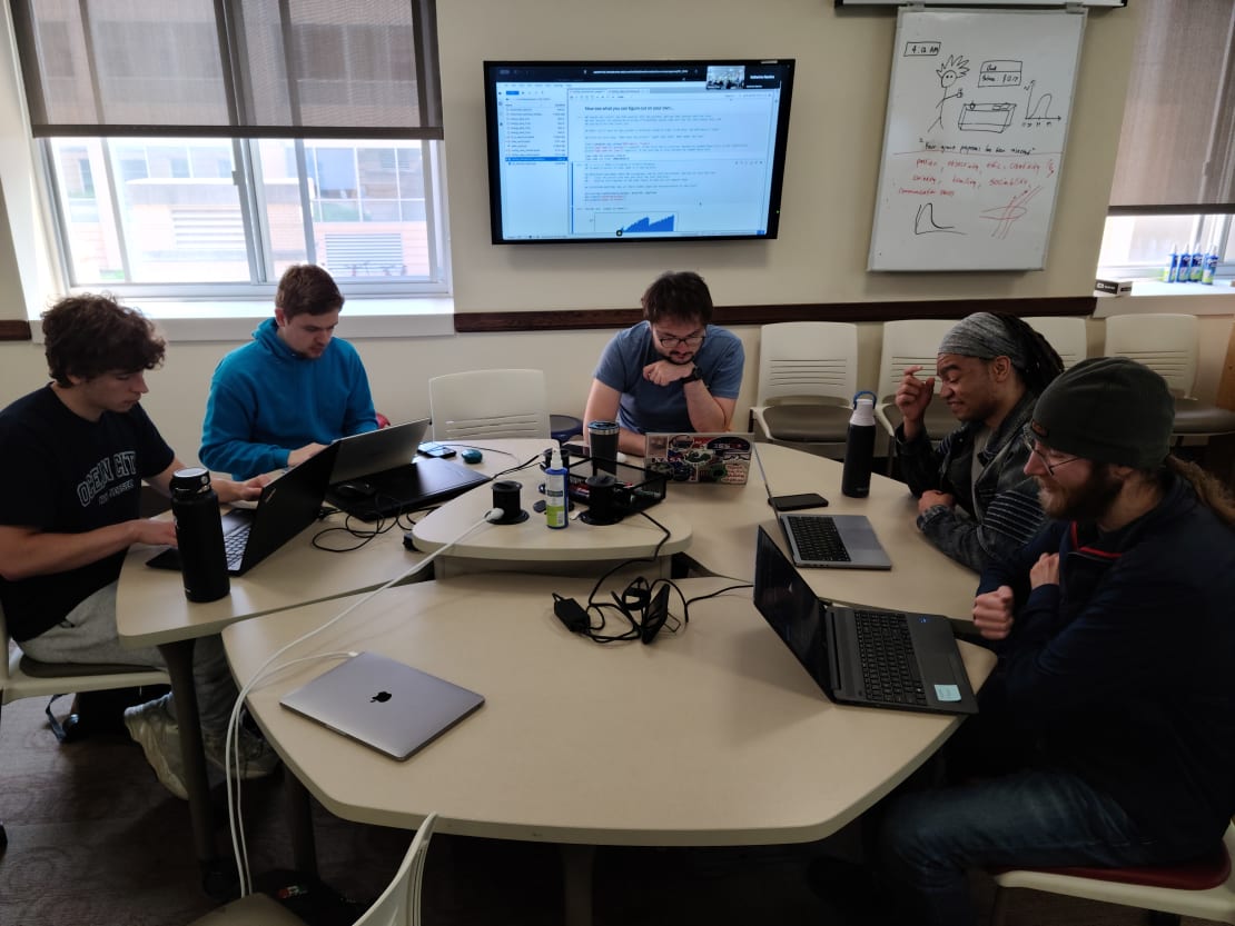 A group of people working on their computers at a table
