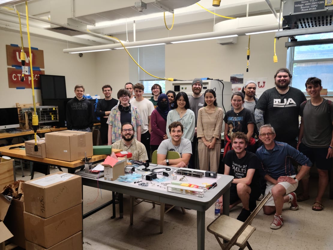 A group of people posing behind a table in a lab