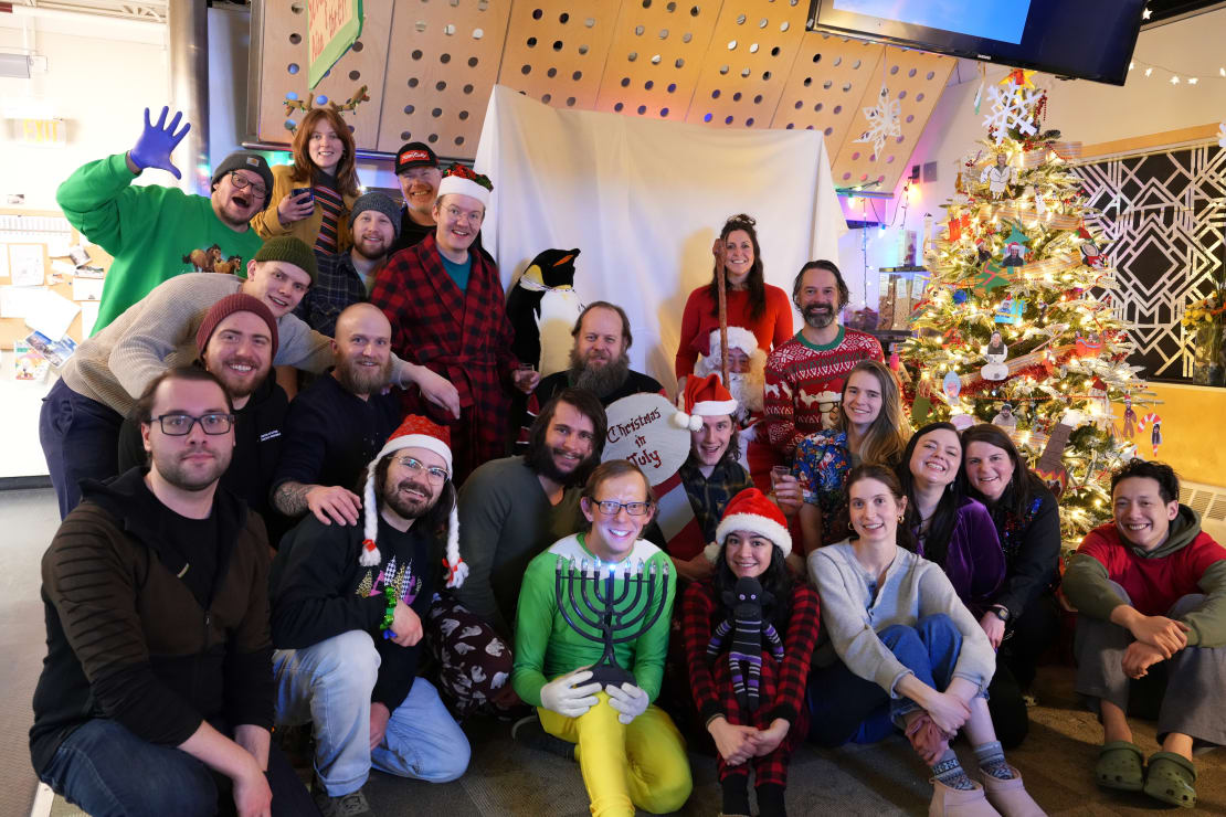 Group photo next to decorated Christmas tree.