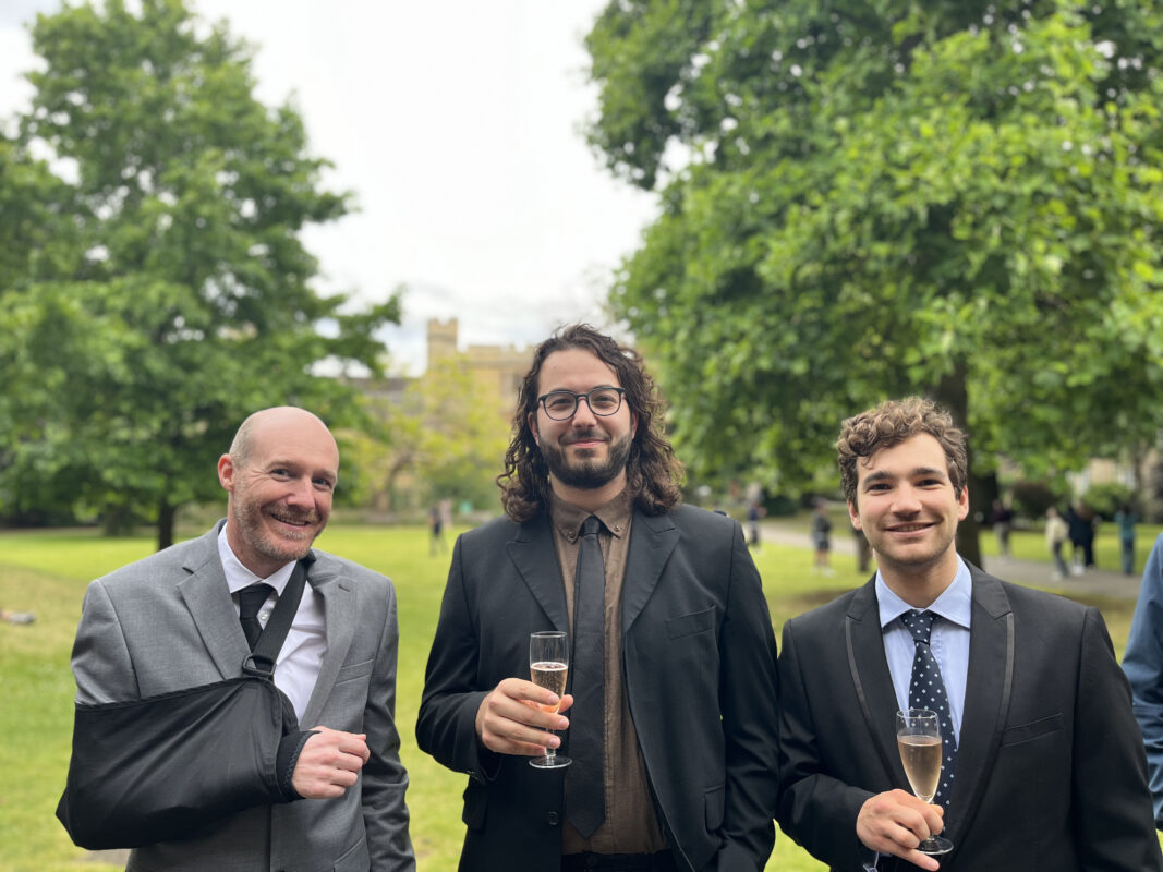 A photo of three people holding glasses of champagne.