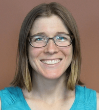 A headshot of a woman with glasses