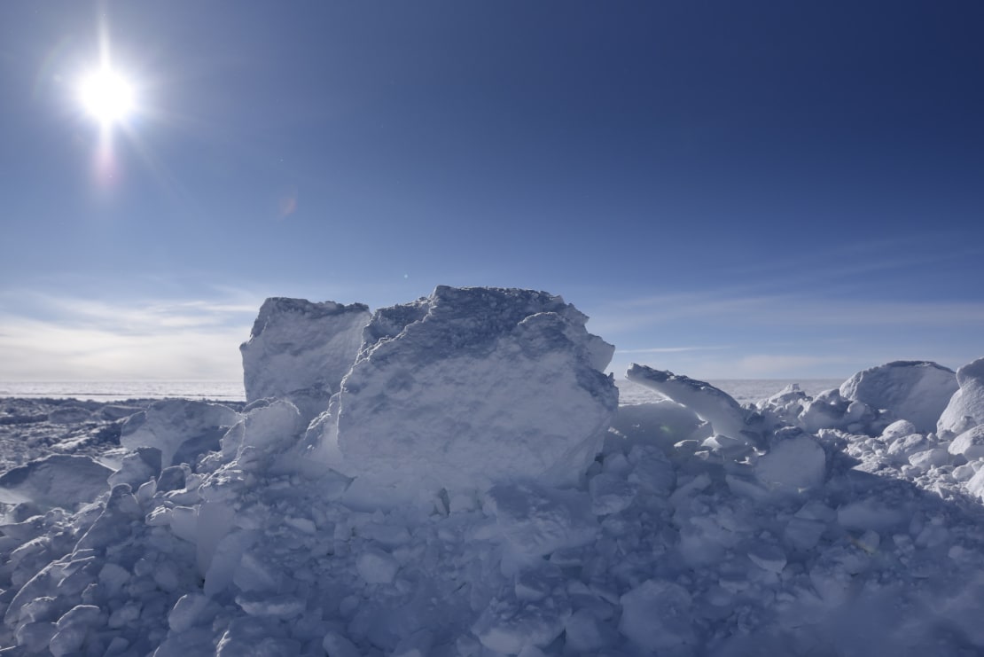 Huge ice blocks at South Pole under sunny sky.