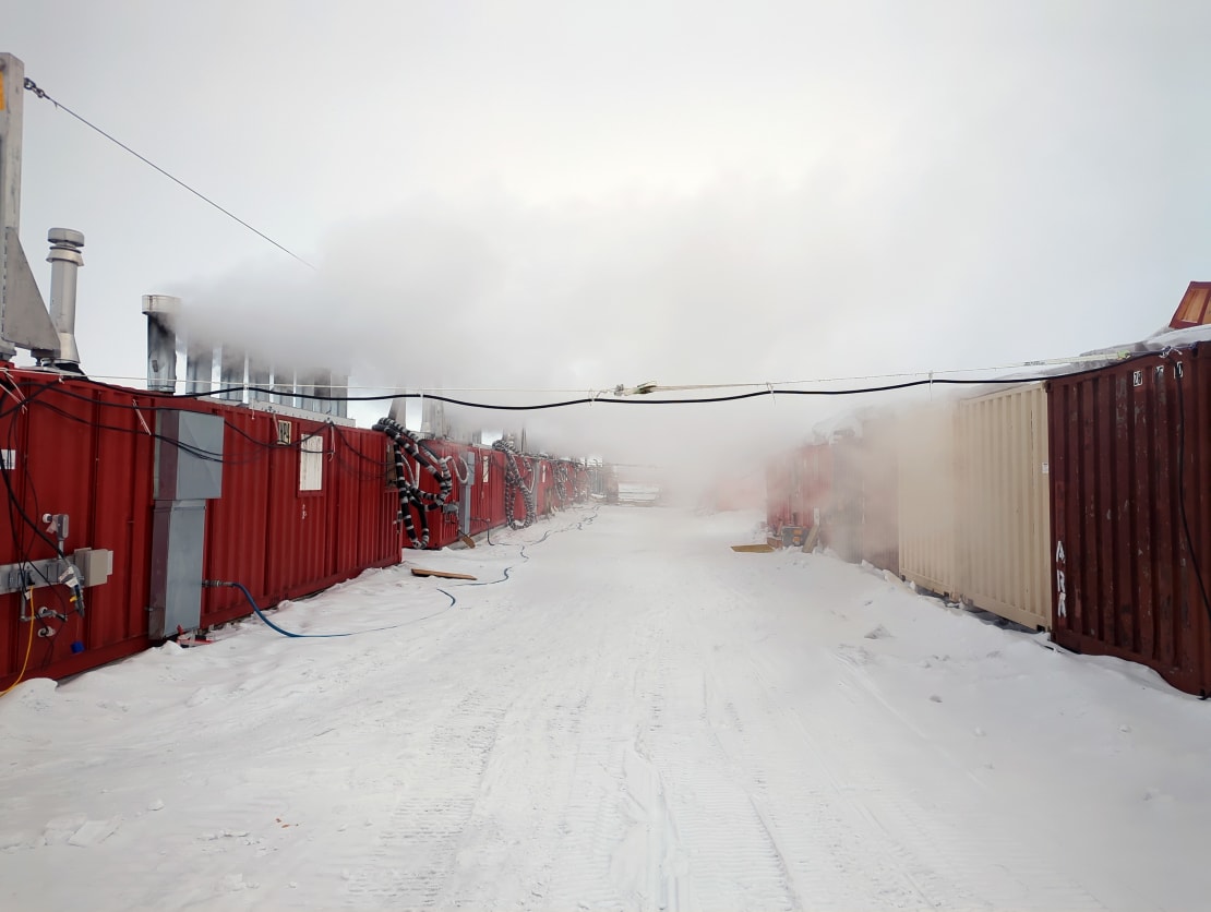 Steam from water heaters filling the space between drill camp containers.