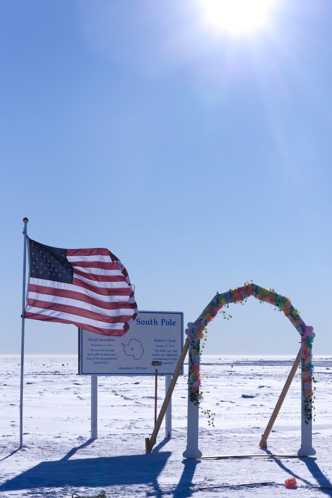 A bright sun over the geographic South Pole where a festooned wedding arch was set up.