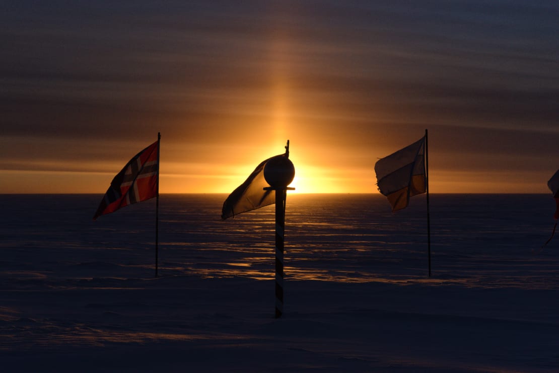 The marker at the ceremonial South Pole centered on the setting sun.