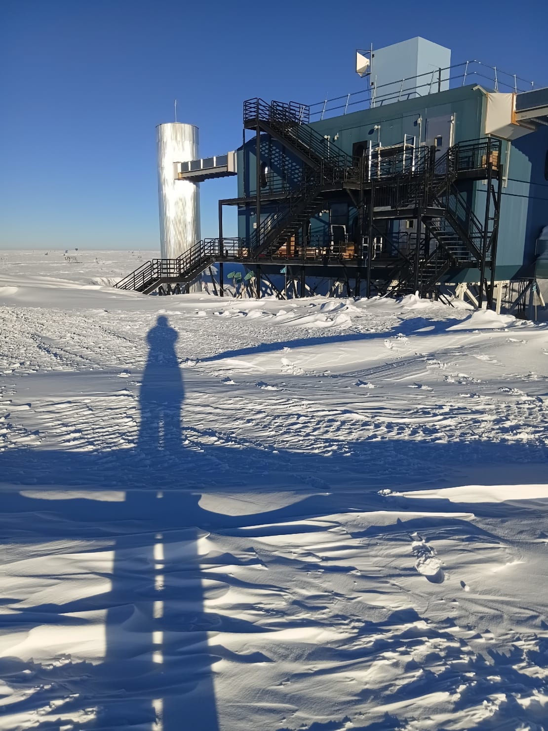 The IceCube Lab top right with long shadow of person bottom left.