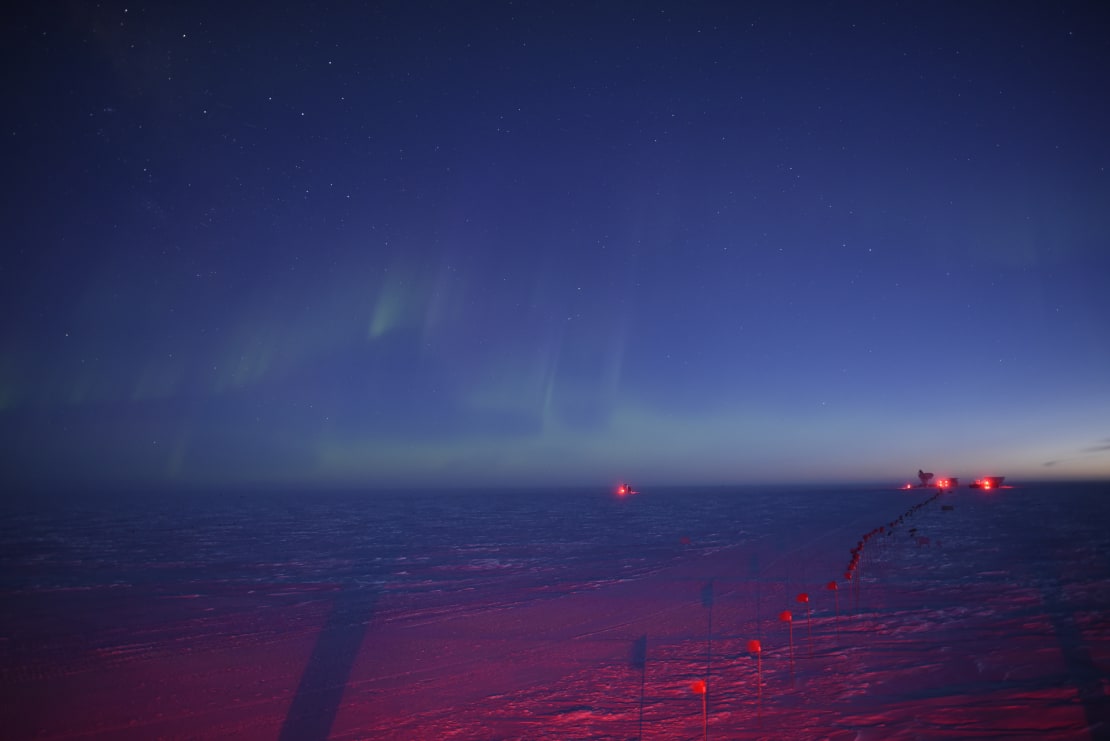 Very faint auroras at the South Pole at twilight, with the sky mostly blue.