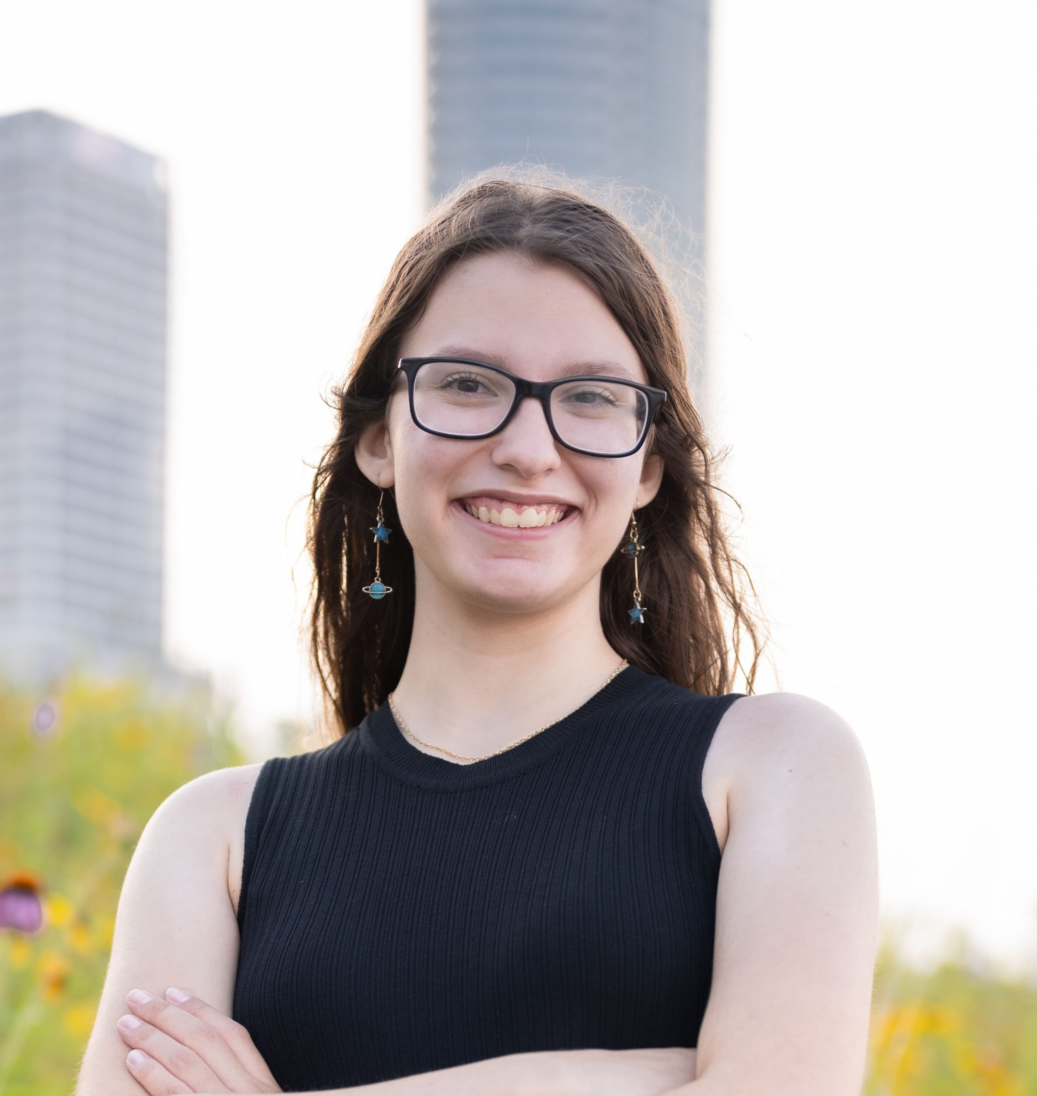 A woman with a black tank top and glasses smiling.