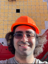 A man with an orange hard hat smiling in a selfie.