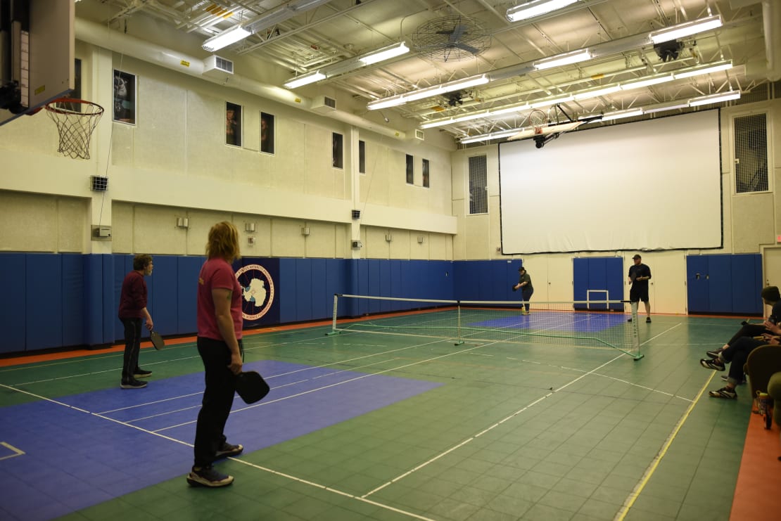 Four people on gym court to play pickleball.