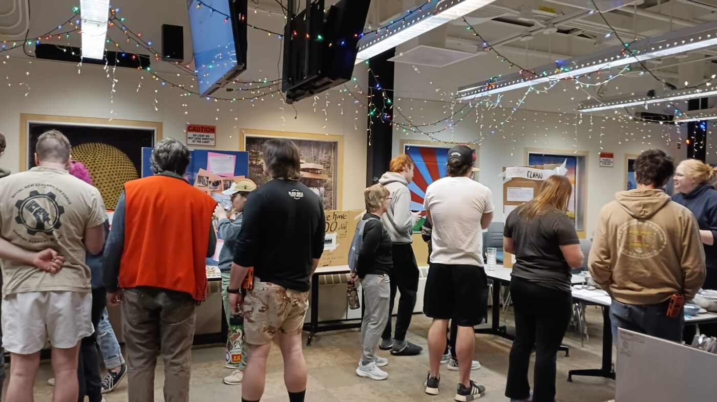 People milling about a group of tables at science fair