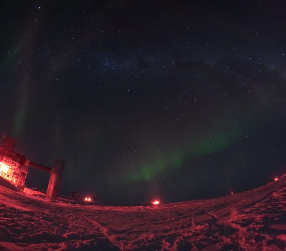 Panoramic view of faint auroras at South Pole, IceCube Lab to the left and South Pole station to distant right
