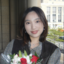 A headshot of a woman smiling with flowers.