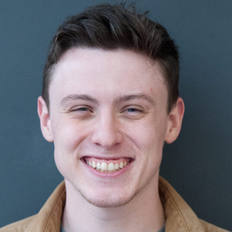 A headshot of a man smiling.