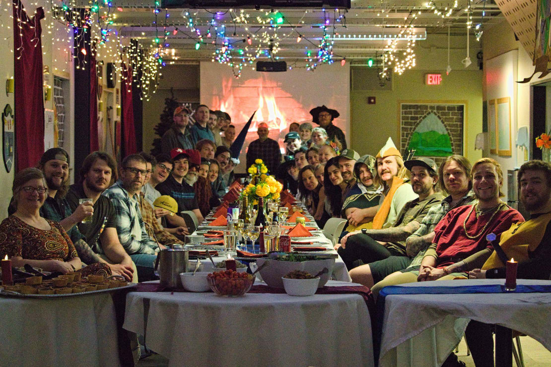 View form the end of long dinner table, set up and decorated with attendees facing camera.