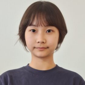 A headshot of a woman with short hair and a blue shirt.