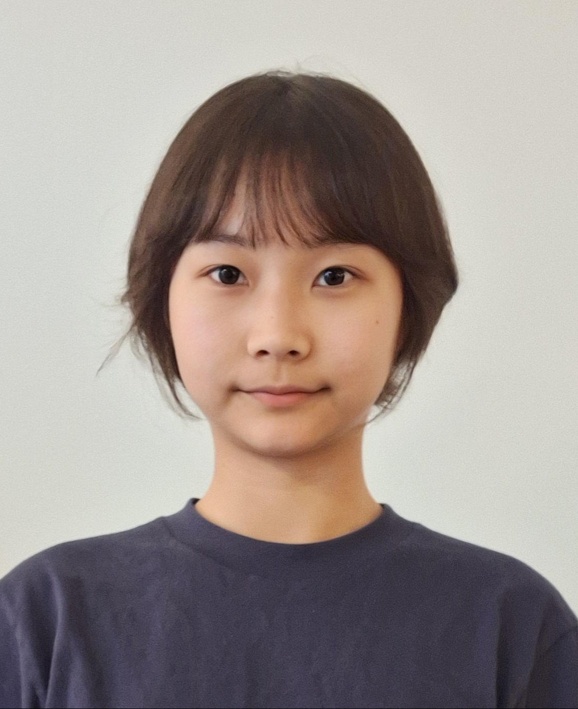 A headshot of a woman with short hair and a blue shirt.